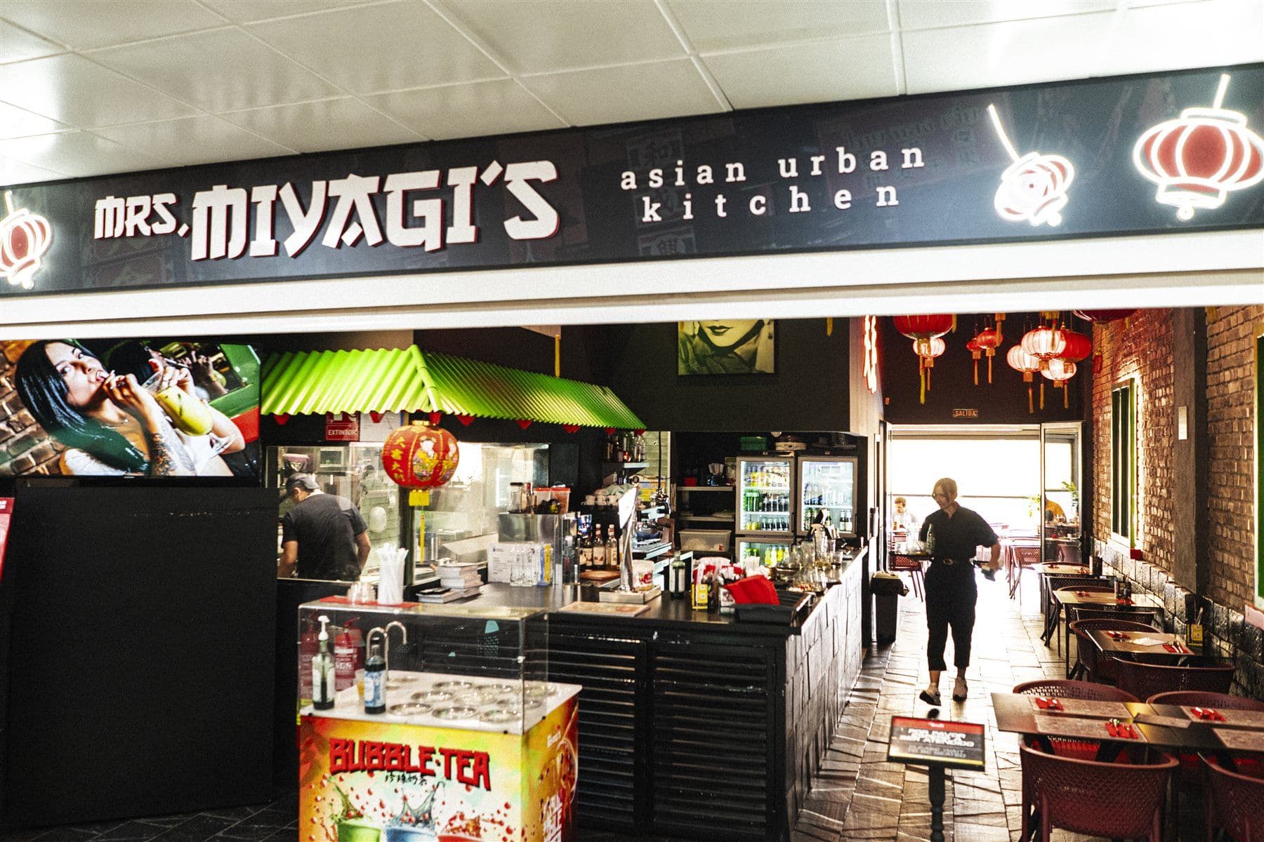 Frente de Mrs Miyagi's en la galería comercial, con el rótulo y el expositor de la entrada