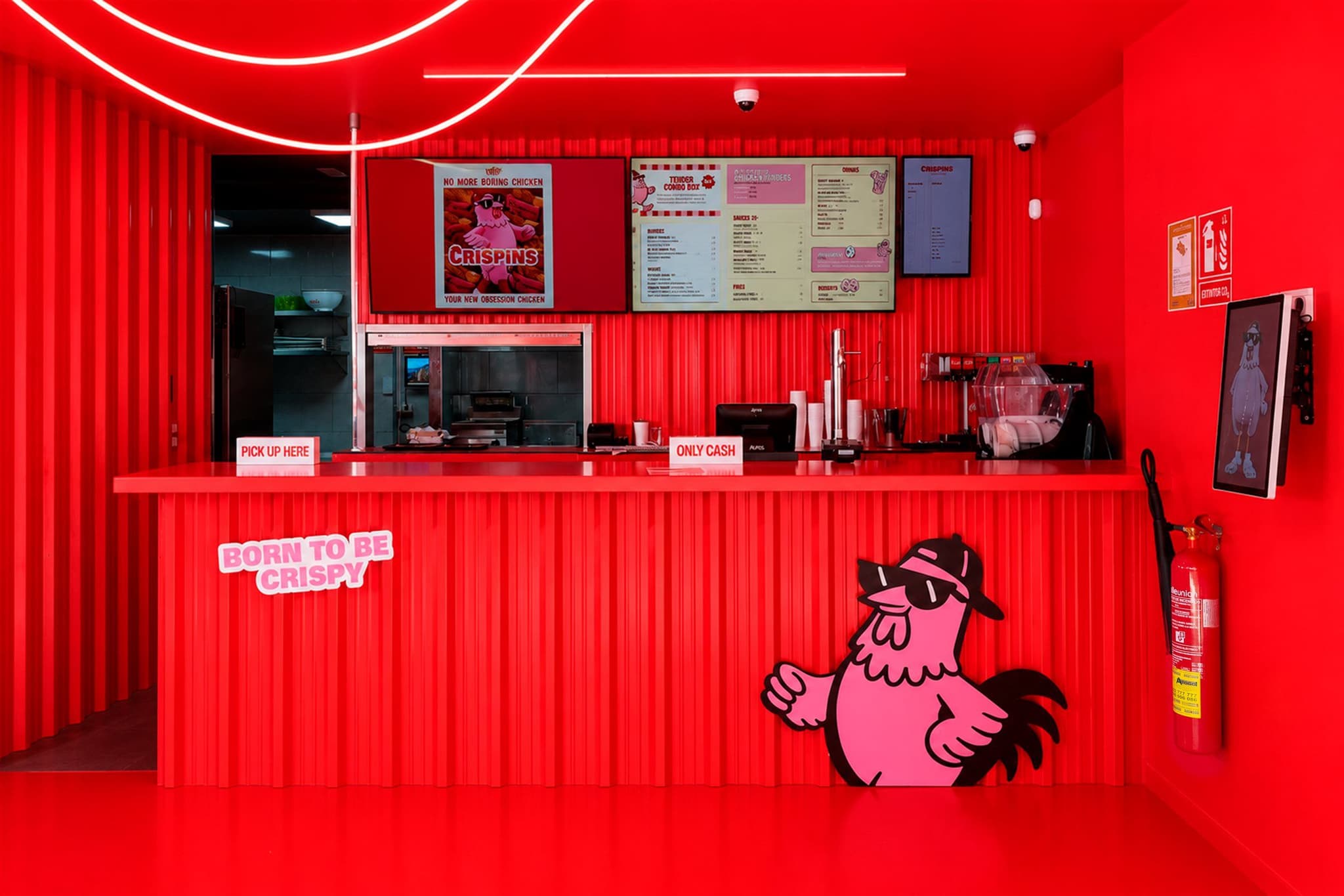 Frente del mostrador de Crispins con la carta iluminada, el logotipo del pollo y el cartel «Born to be Crispy»